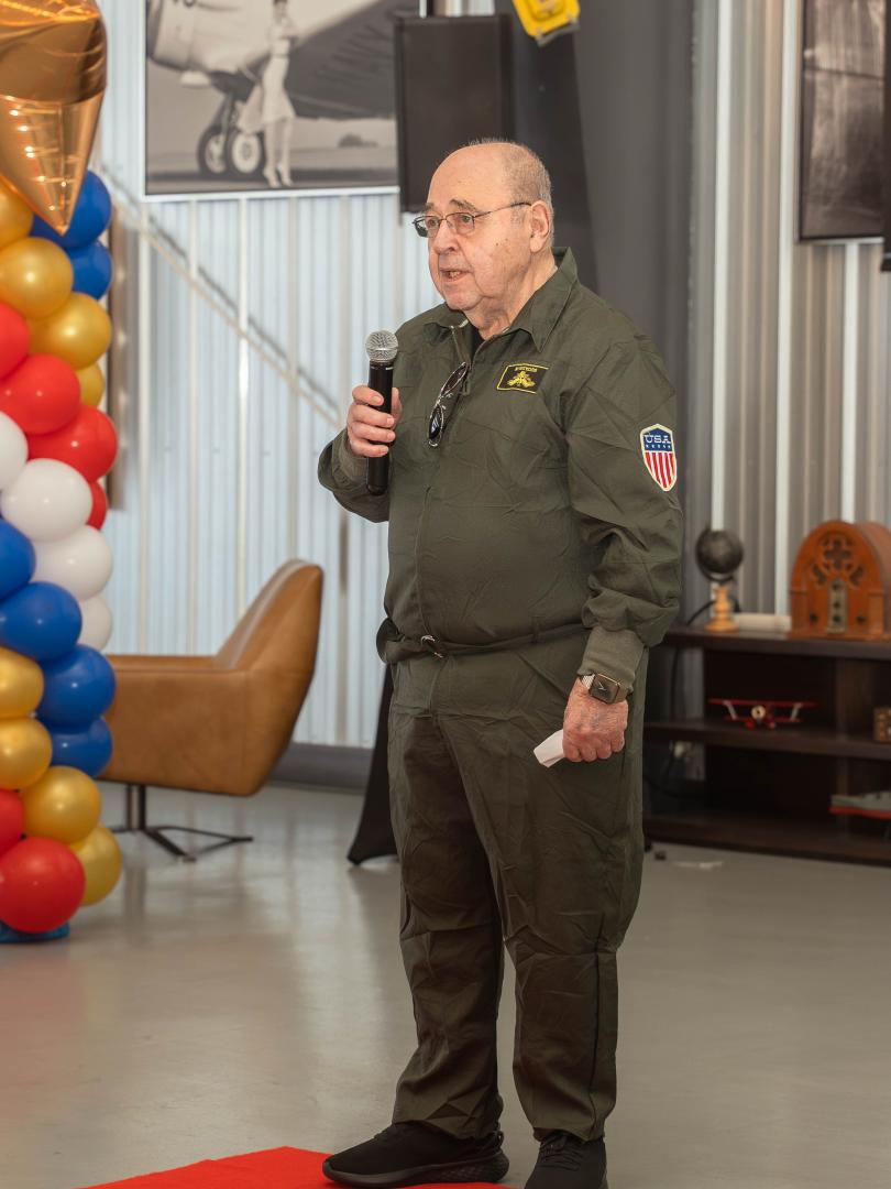 Wally Altes in flight suit announcing match
