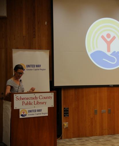 Digital Equity Speaker at podium in front of UW Logo