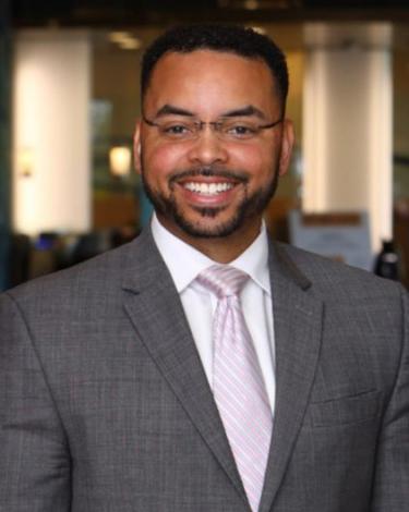 Michael-Aaron in gray suit pink tie smiling