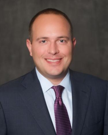 Ryan with suit and purple tie smiling