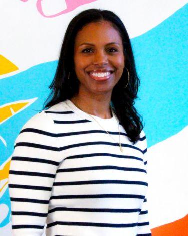 Eryka Jenkins in stripe shirt against colorful wall